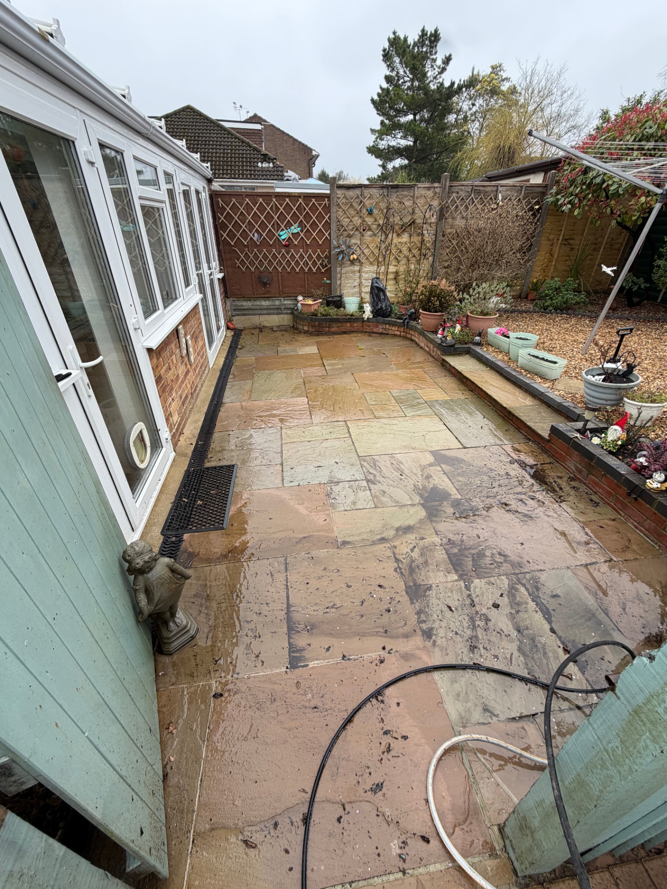 Indian sandstone patio beside conservatory before cleaning